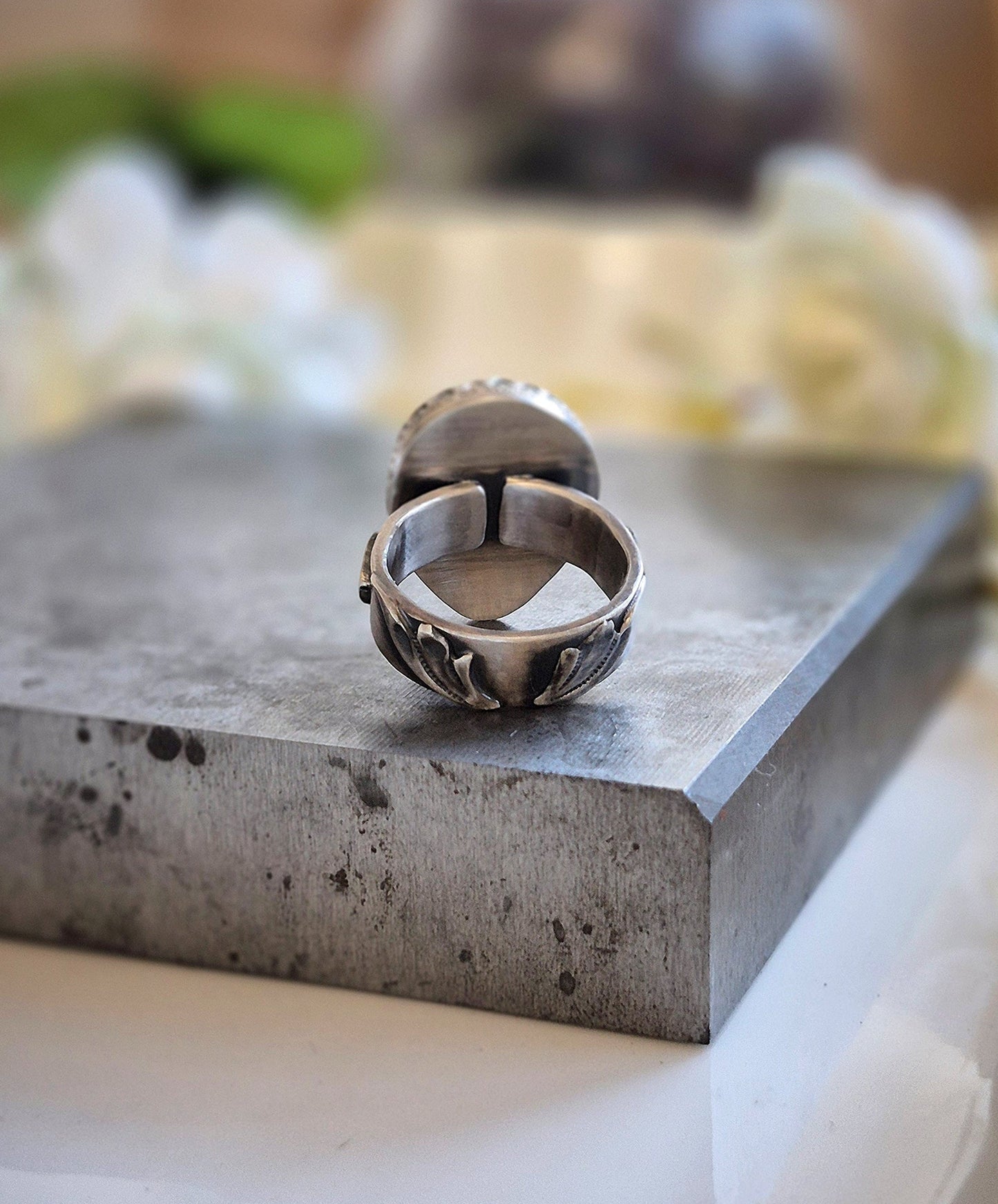 Silver ring on a concrete surface with blurred background