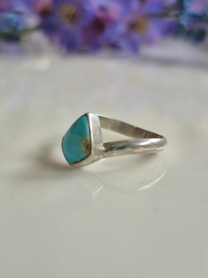 Silver ring with a turquoise stone on a white background