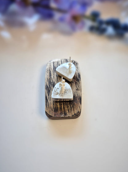 Wooden display with crescent-shaped earrings on a neutral background