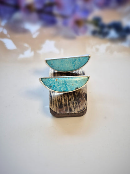 Earring with turquoise stones on a white surface