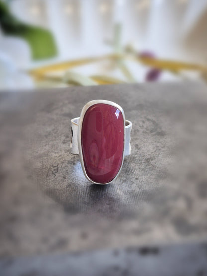 Ring with a pink-red rosarita stone on a textured surface