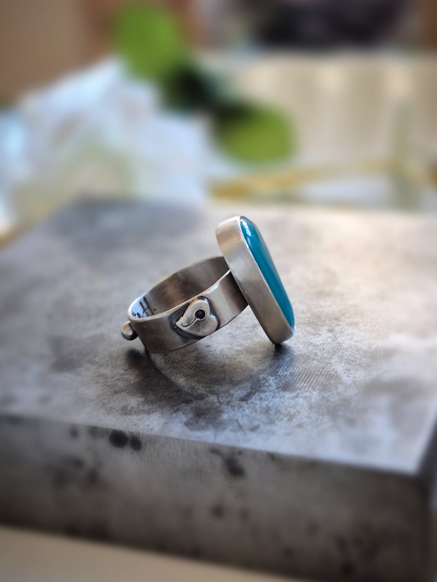 Silver ring with a blue gem silica gemstone on a textured surface