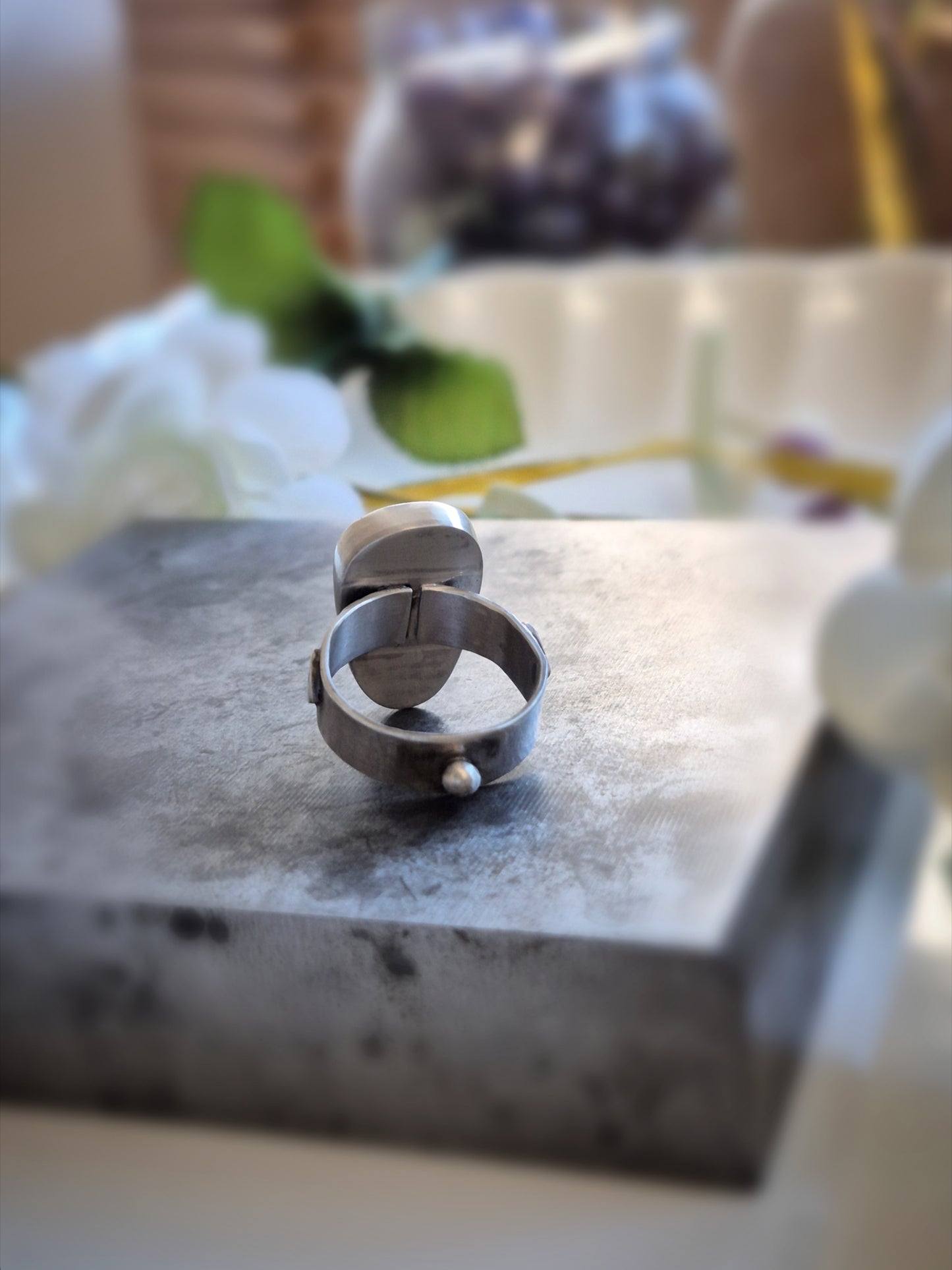 Silver ring  backside on a marble surface with blurred background