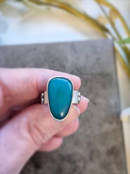 Gemsilica ring on a finger with a blurred background