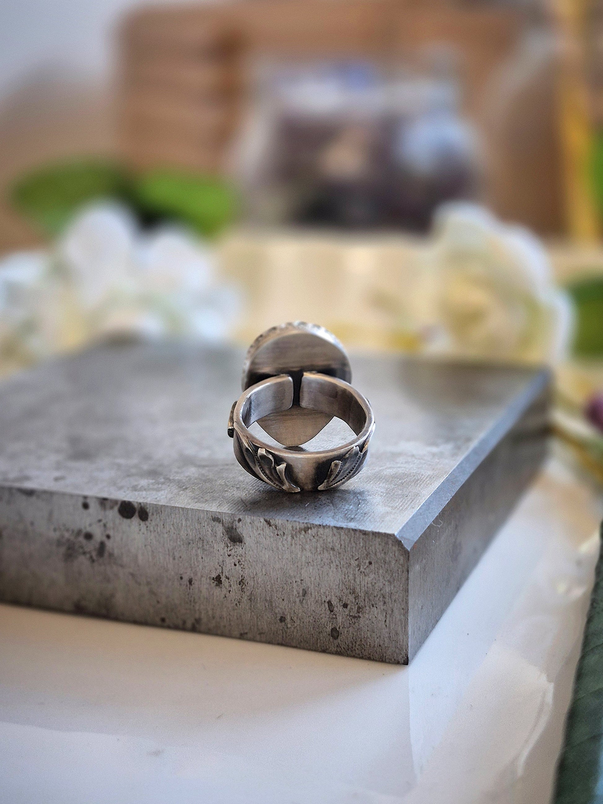 Silver ring on a concrete surface with blurred background