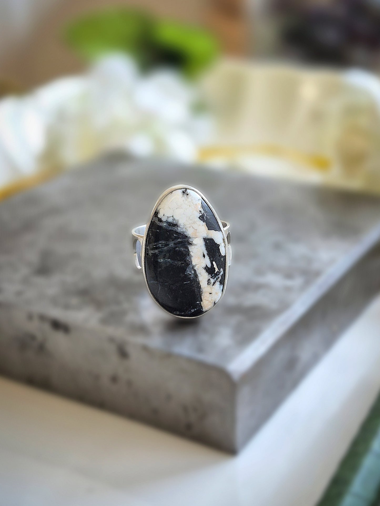 Silver ring with a white buffalo gemstone on a gray surface