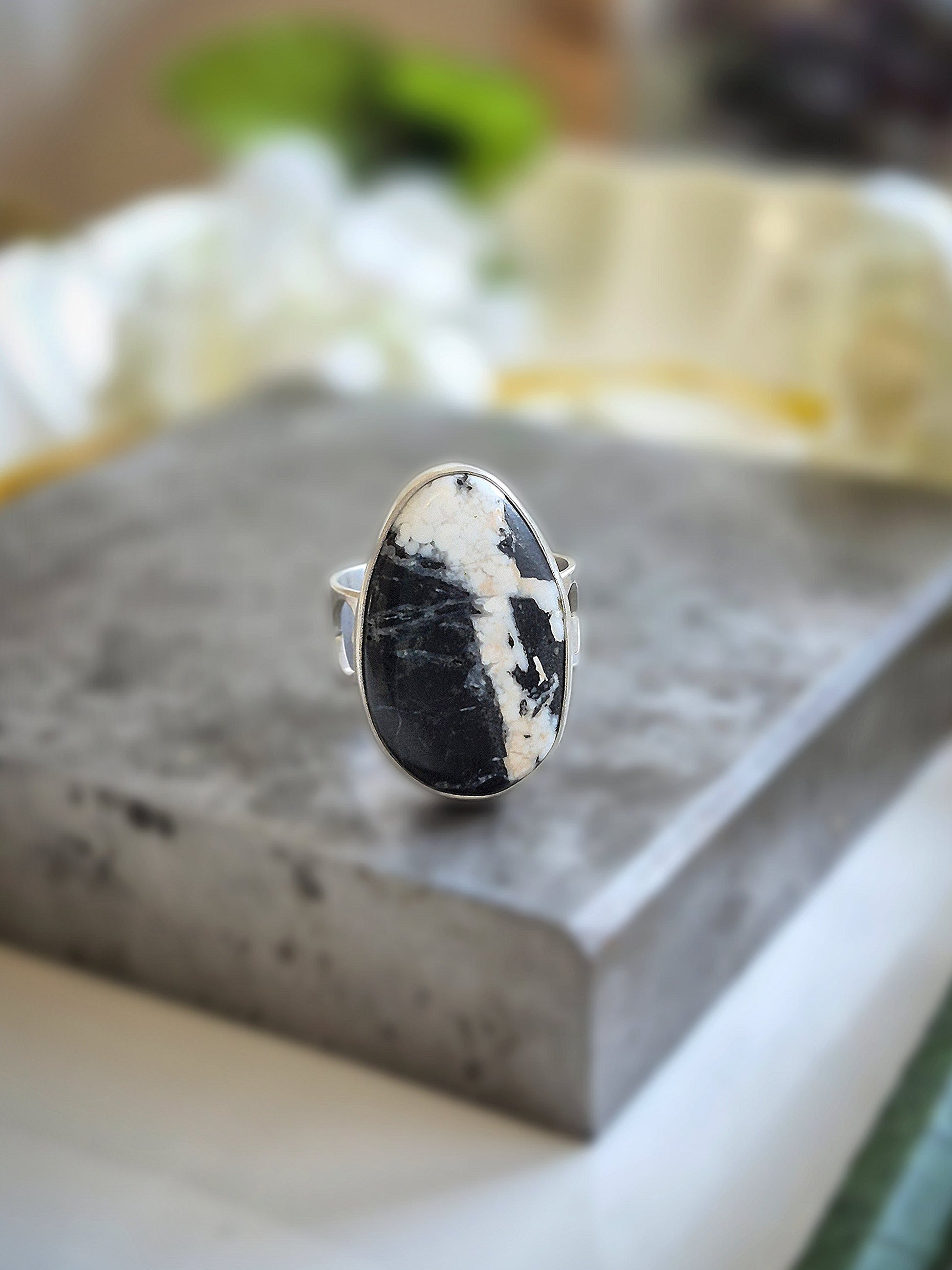 Silver ring with a white buffalo gemstone on a gray surface