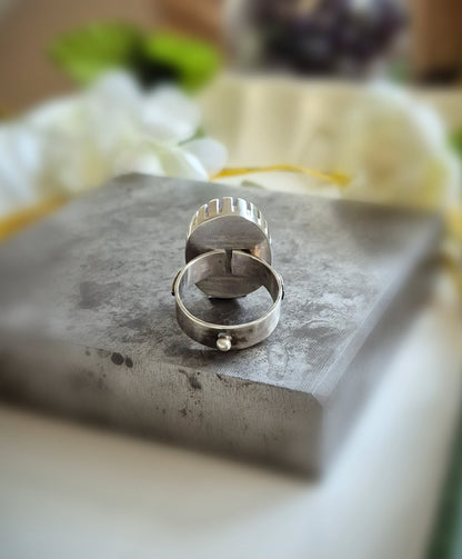 Silver ring on a textured surface with a blurred background