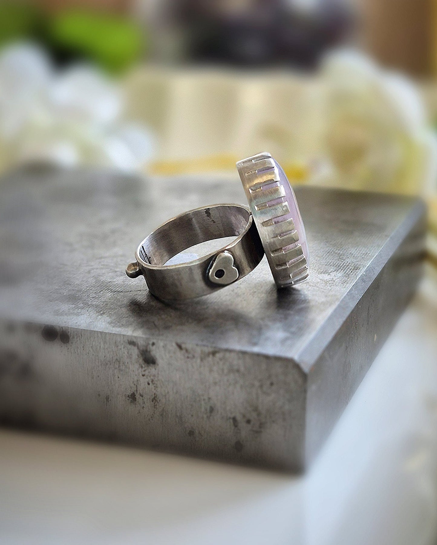 Silver ring on a textured surface with a blurred background